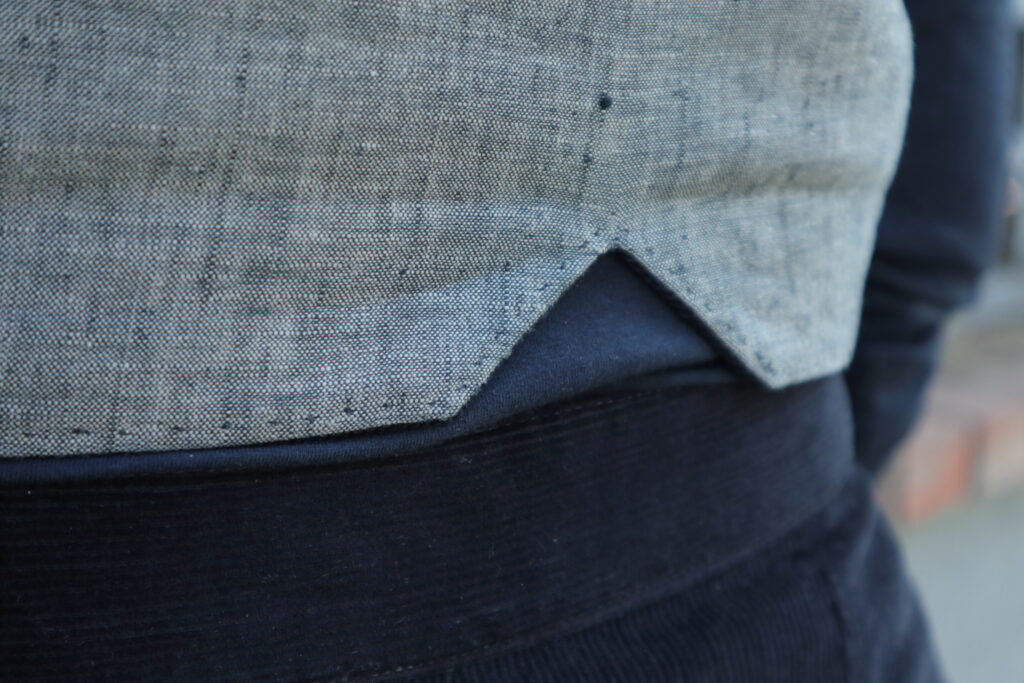 Back detail of grey vest.