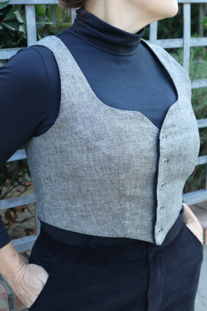 Close up of grey vest and black top.
