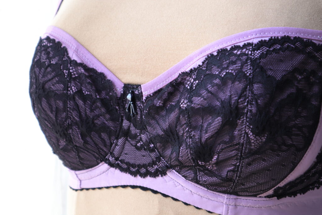Close up front detail of purple bra with black lace and beading