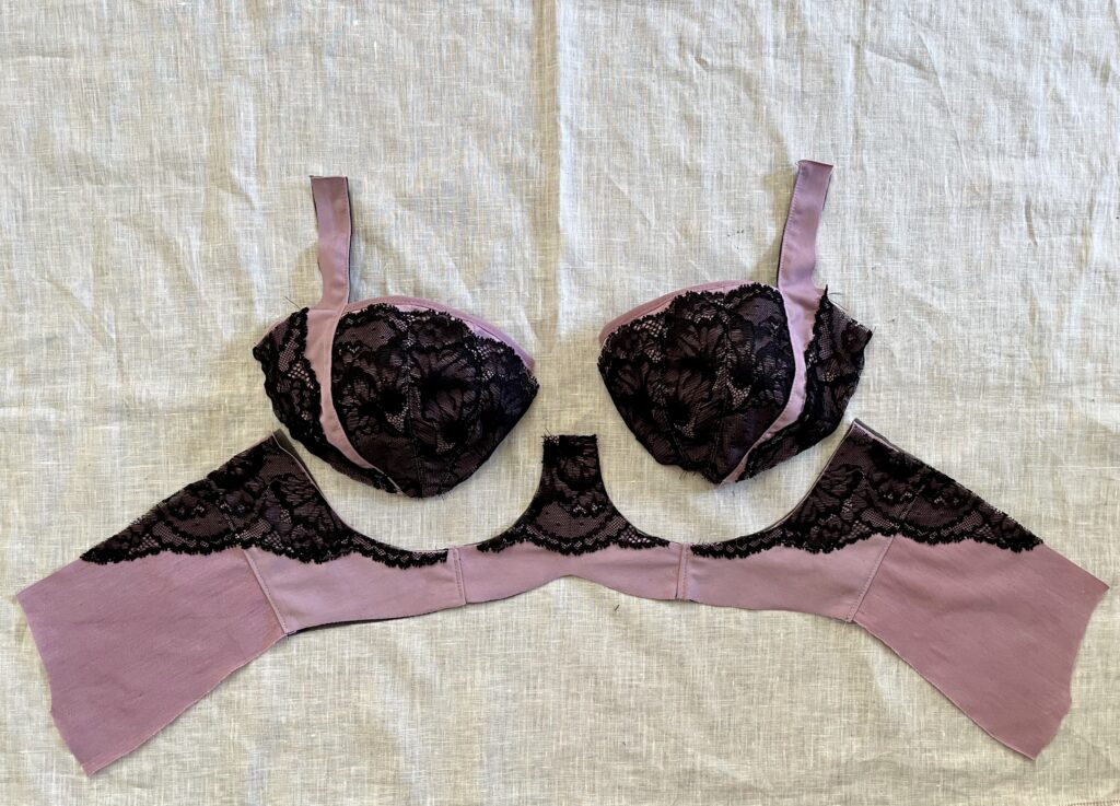 Deconstructed purple bra with black lace on white linen