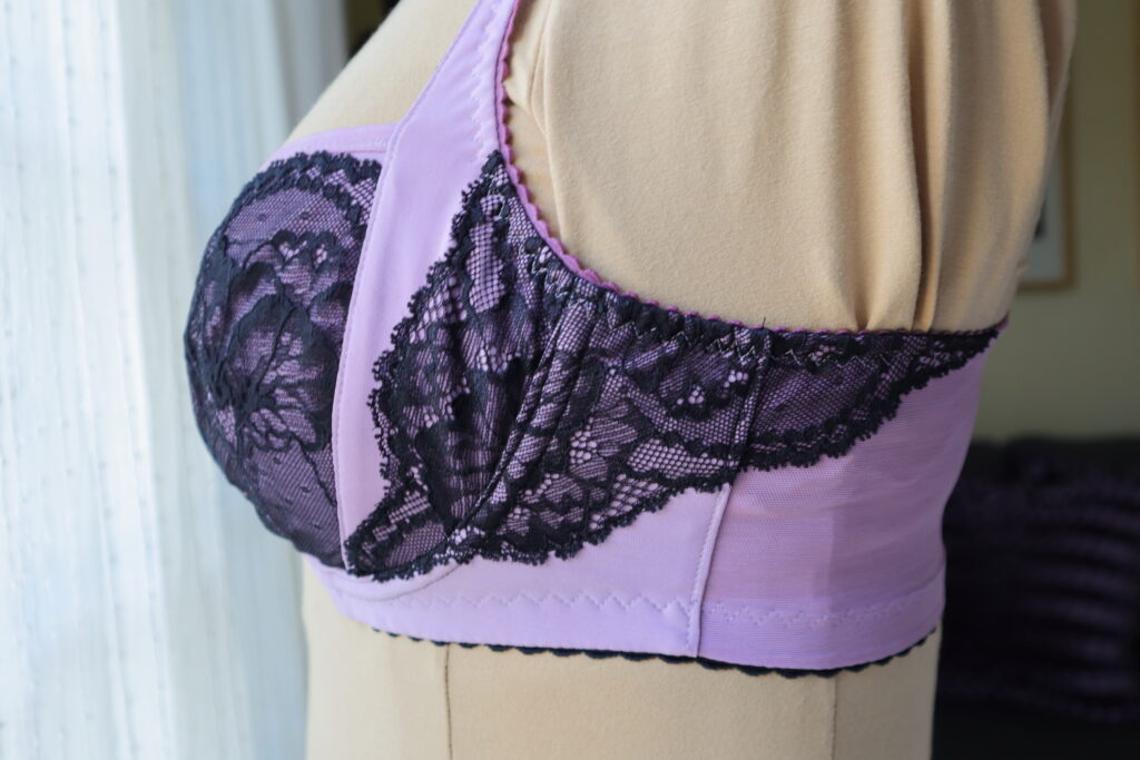 Close up side detail of purple bra with black lace on mannequin