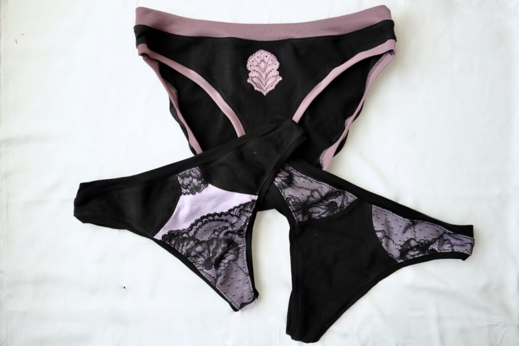 Three pair of black and purple underwear with lace accents