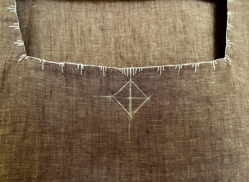 Detail of square neckline on brown linen top with diamond chalk sketch 