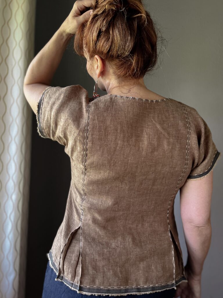 Back view detail of a brown embroidered women's linen top