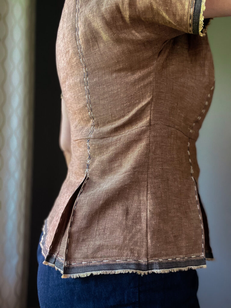 Side view detail of a brown embroidered women's linen top