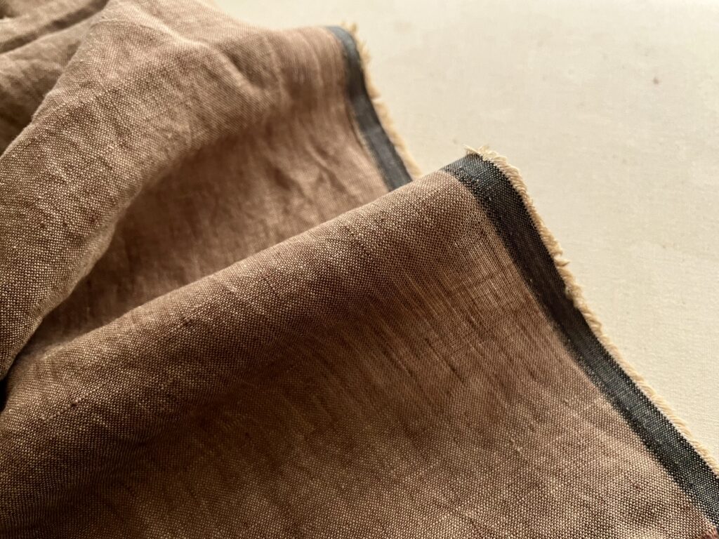 Detail of brown linen fabric with grey edge